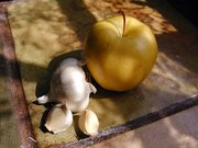 A garlic bulb, showing indiviual cloves near an apple. A clove of garlic is also known as a toe.